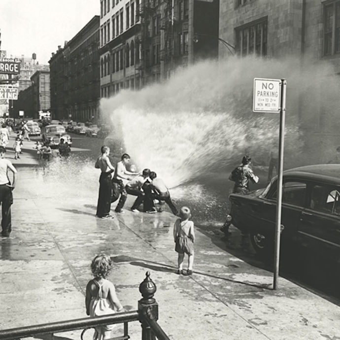 Children playing with a bursting fire hydrant.